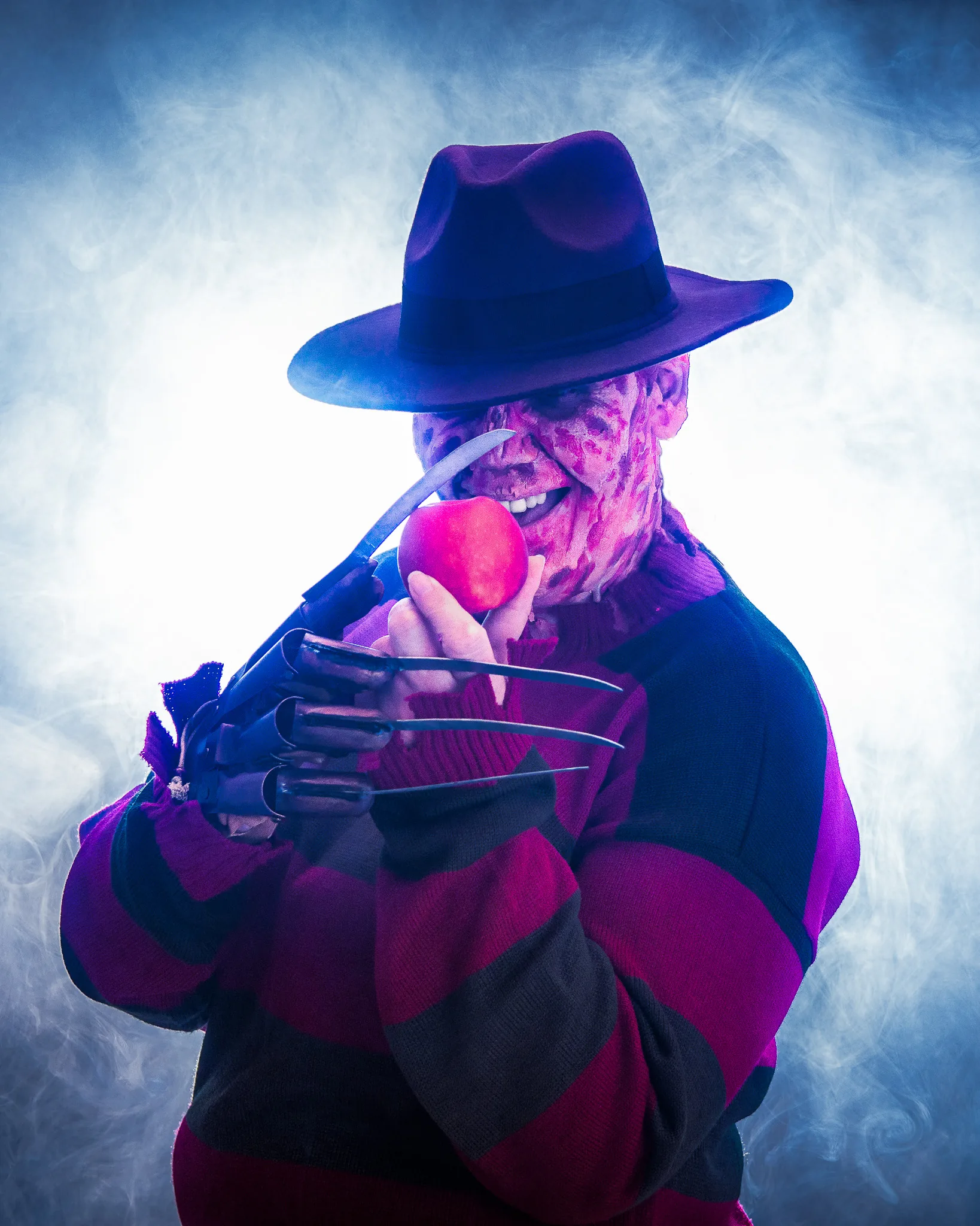 Kreativshooting: Cosplay einer Horrorfigur mit Hut und Klingenhandschuh im Nebel