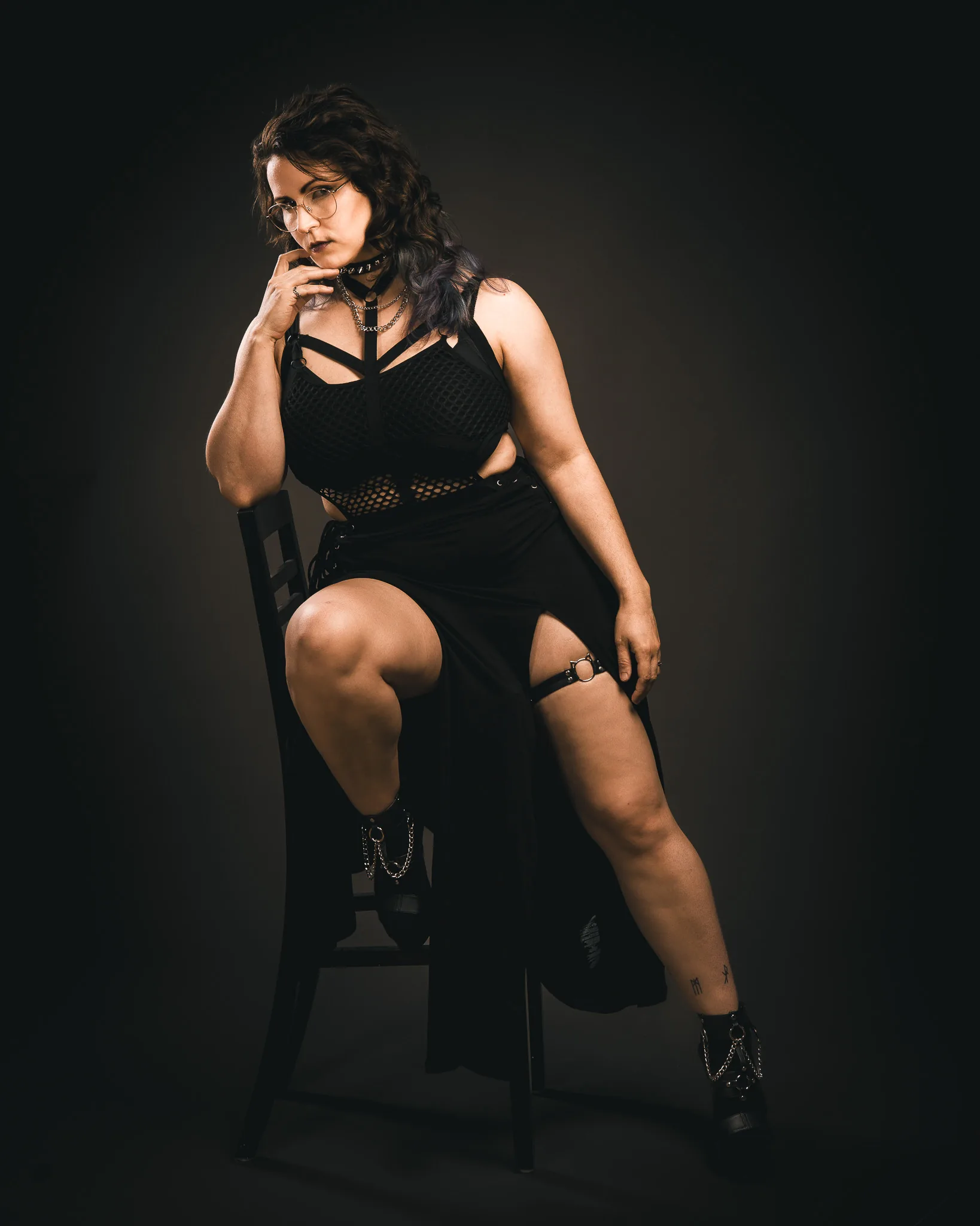 Portraitshooting im Studio: selbstbewusste Pose auf einem Stuhl im Gegenlicht
