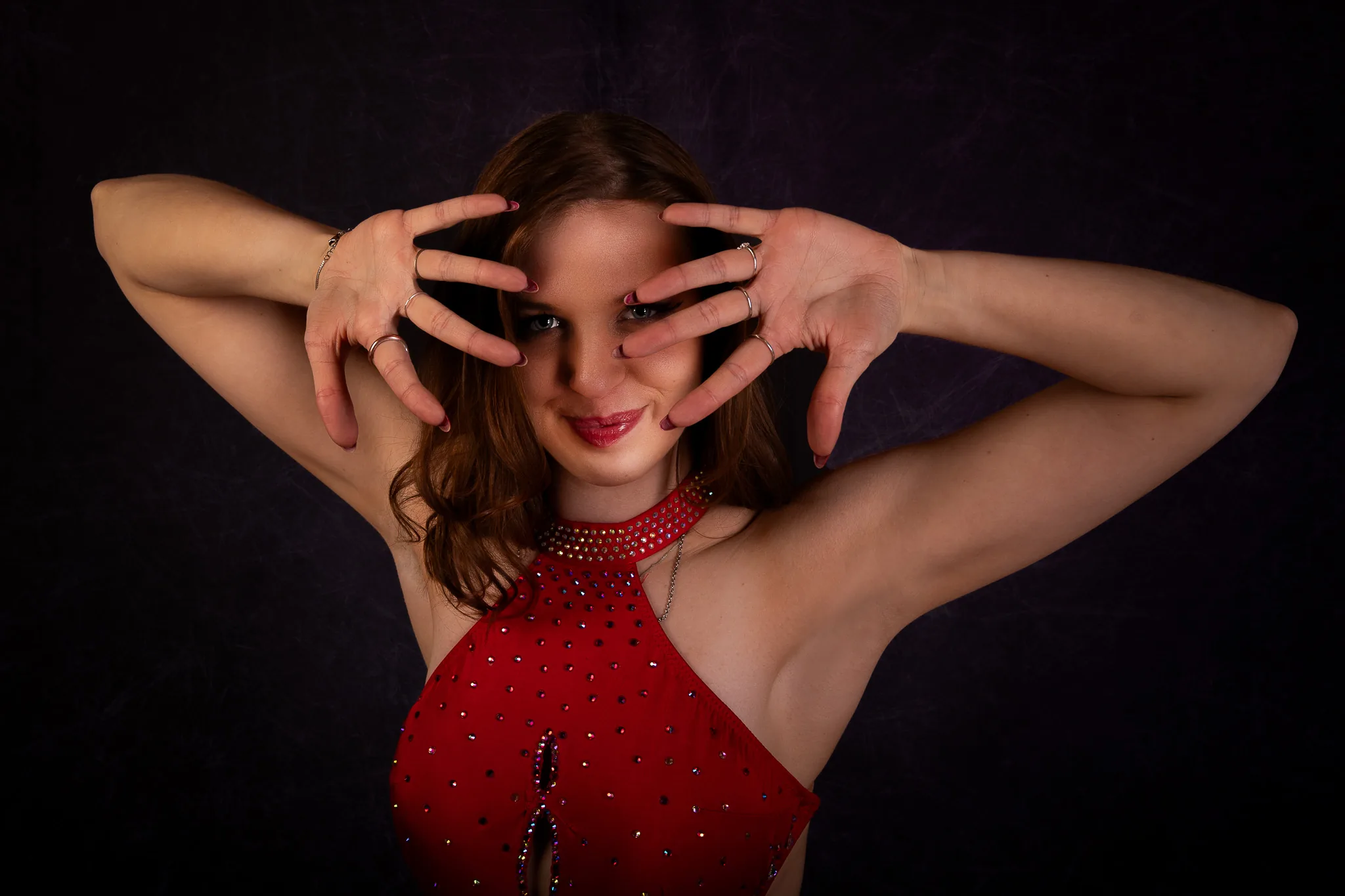 Portraitshooting: Tänzerin im roten Kleid, die Hände rahmen das Gesicht