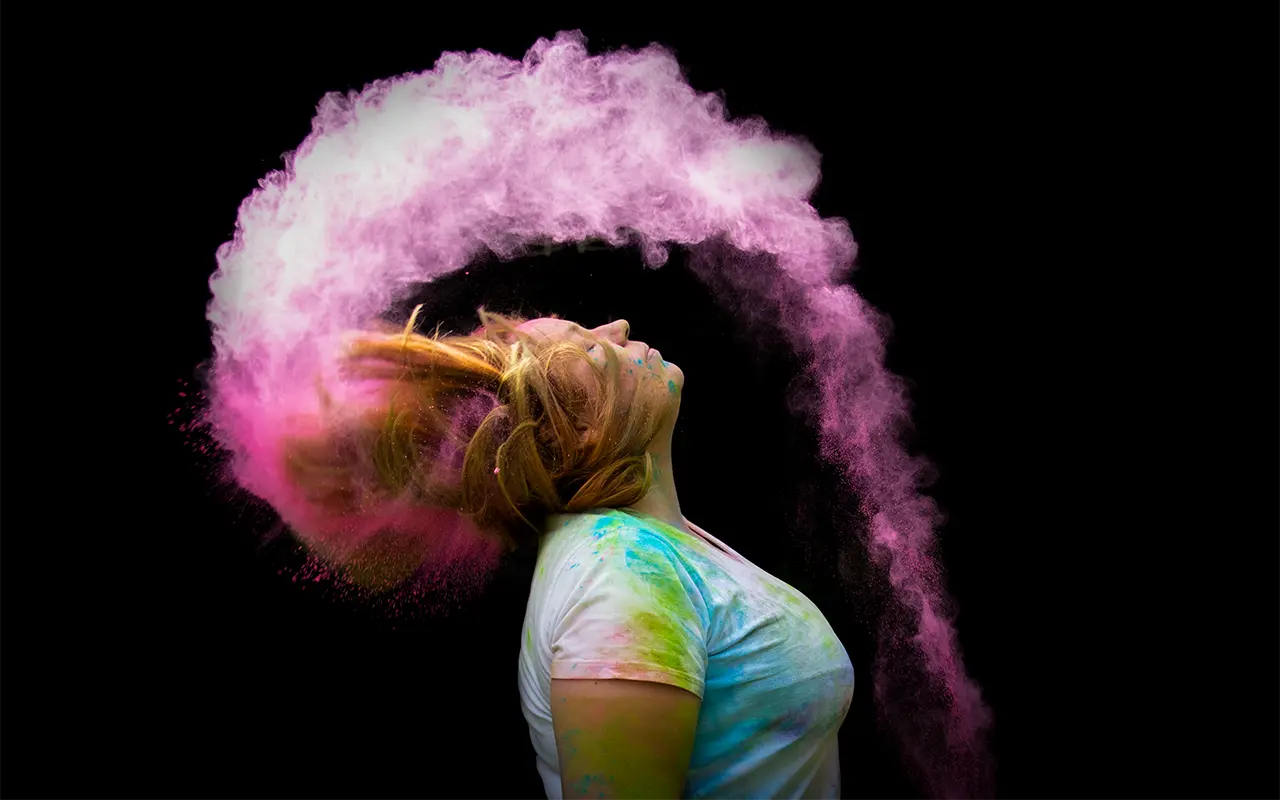 Frau, die ihre Haare mit Holi-Pulver nach hinten wirft. Marcus Beelitz Fotografie